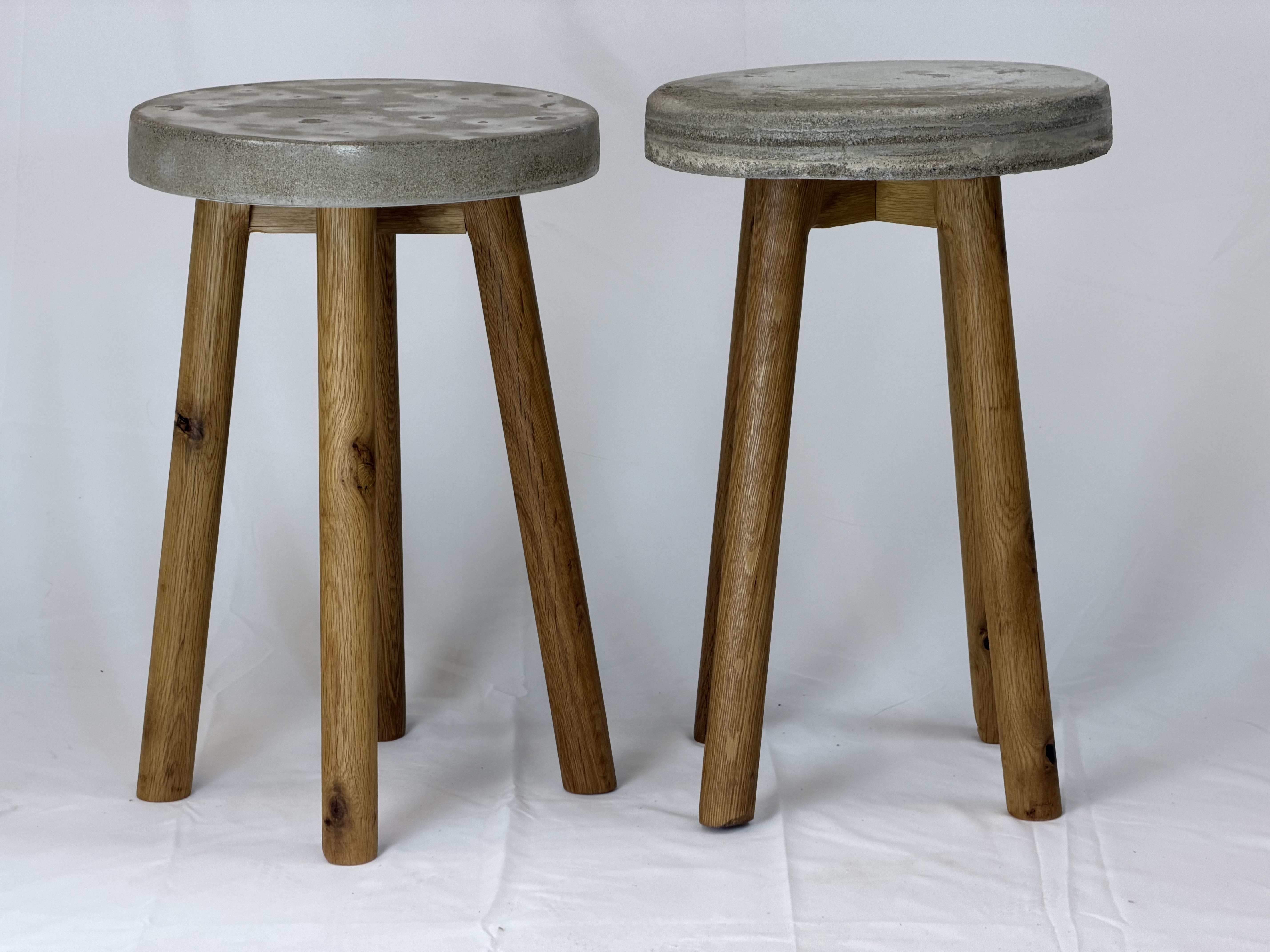 Three-quarters perspective showcasing turned timber legs embedded into concrete tops